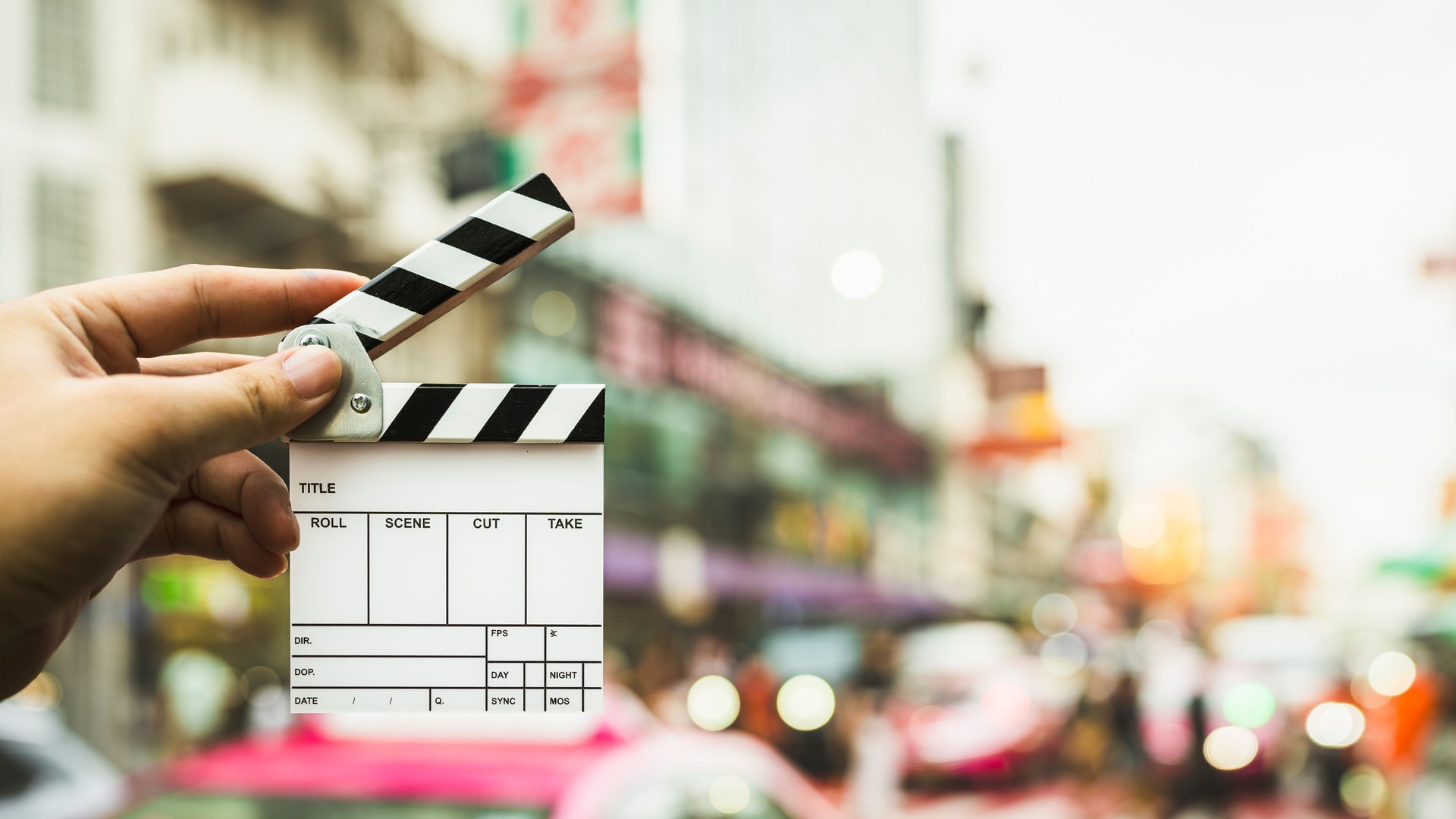 Assistant director holding a film slate on Yaowarat Road, which is Thailand's Chinatown and is popular for filming concept films about the film industry and shooting content on social media.
